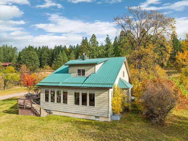 back of property with a deck and a lawn