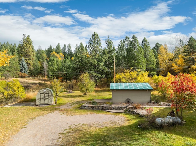 view of property's community with a storage unit and a yard