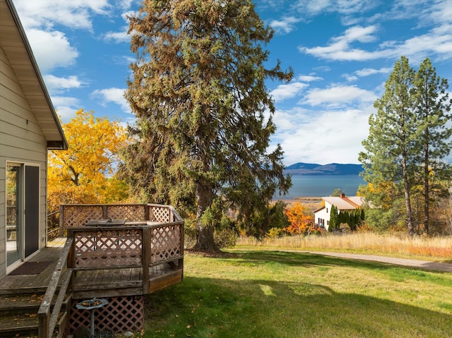 view of yard with a deck with water view