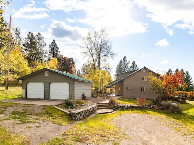 view of side of home featuring an outbuilding and a garage