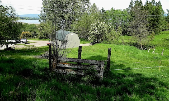 view of yard featuring a water view and a shed