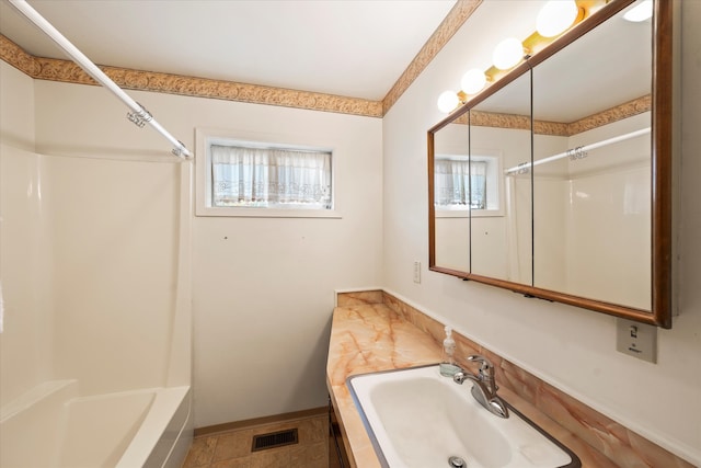 bathroom with vanity, tile patterned flooring, a healthy amount of sunlight, and  shower combination