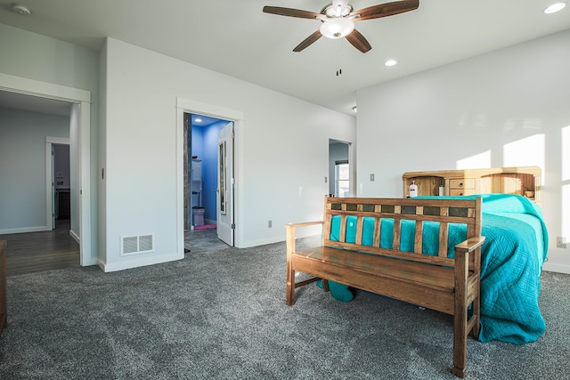 bedroom featuring ensuite bathroom, dark carpet, and ceiling fan