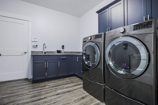 laundry area with sink, dark wood-type flooring, washing machine and dryer, and cabinets