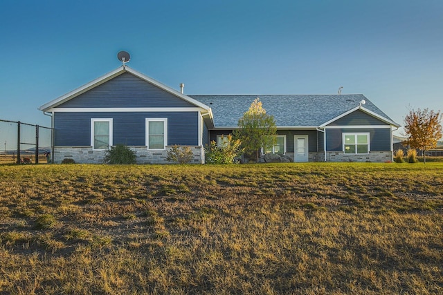 ranch-style house with stone siding and a shingled roof