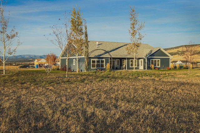 back of house featuring a yard and a mountain view