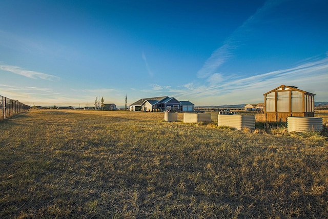 view of yard featuring a greenhouse, an outbuilding, and a view of rural / pastoral area