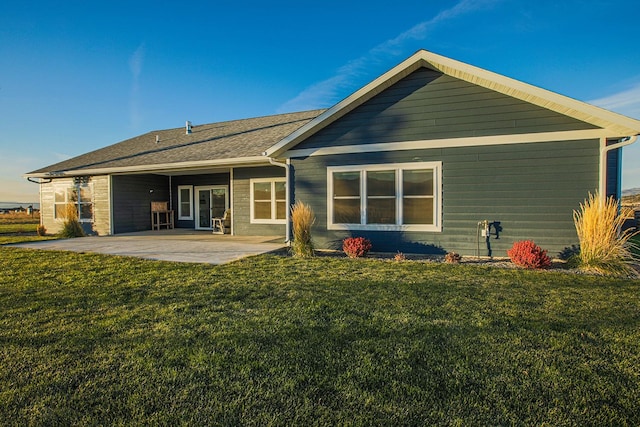 back of property with a patio area and a lawn