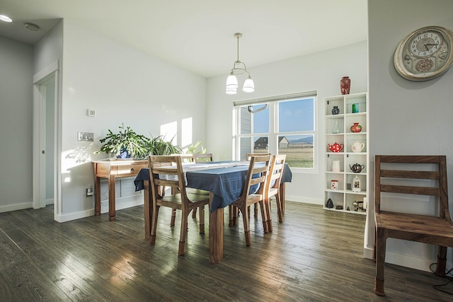 dining space with dark wood-style flooring, baseboards, and a chandelier