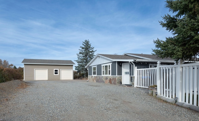 view of front facade featuring a garage and an outbuilding