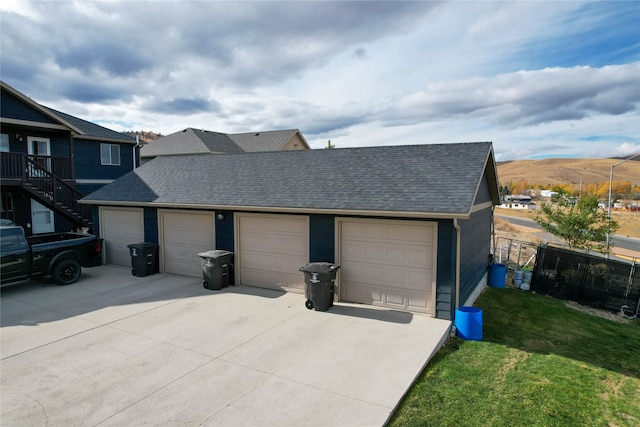 exterior space with a mountain view, a front yard, and a garage