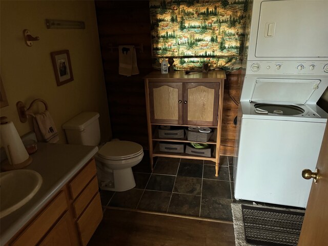 bathroom with toilet, vanity, tile patterned floors, and stacked washer and dryer