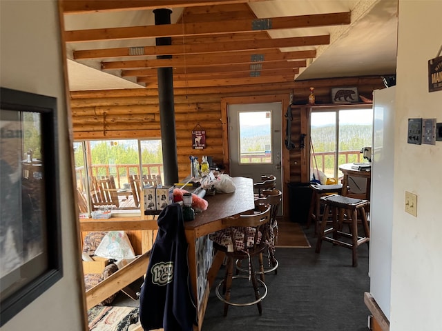 carpeted dining room with a wealth of natural light and log walls