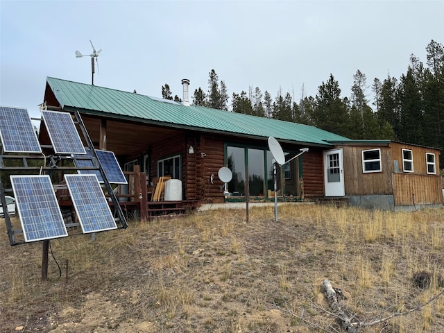 back of property featuring solar panels