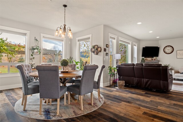 dining space with dark wood-type flooring and a notable chandelier