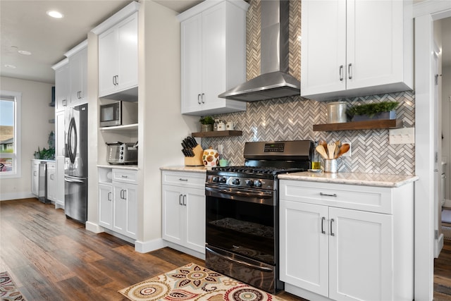 kitchen featuring backsplash, white cabinetry, stainless steel appliances, wall chimney exhaust hood, and dark wood-type flooring