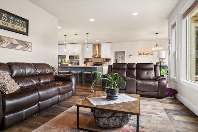 living room with an inviting chandelier and dark hardwood / wood-style flooring