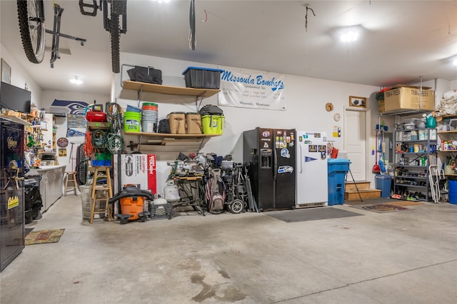 garage with black refrigerator with ice dispenser and white refrigerator