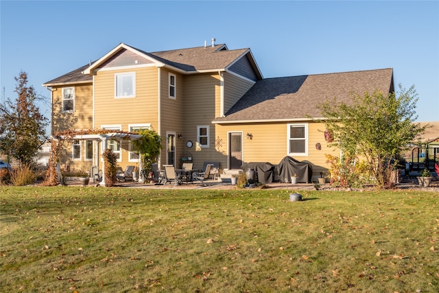 rear view of property featuring a patio area and a lawn