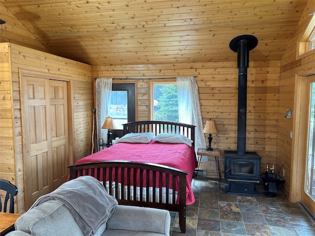 NHN Lupfer Meadows Rd, Whitefish, MT 59937 - bedroom featuring wooden walls, a wood stove, stone finish flooring, lofted ceiling, and a closet