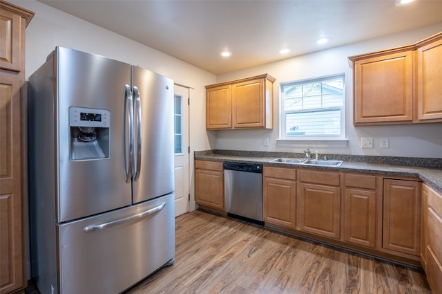 kitchen with sink, wood-type flooring, and appliances with stainless steel finishes