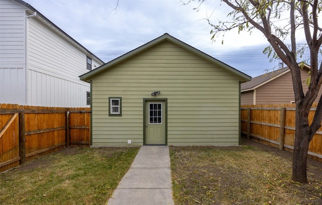 rear view of house featuring an outbuilding and a yard