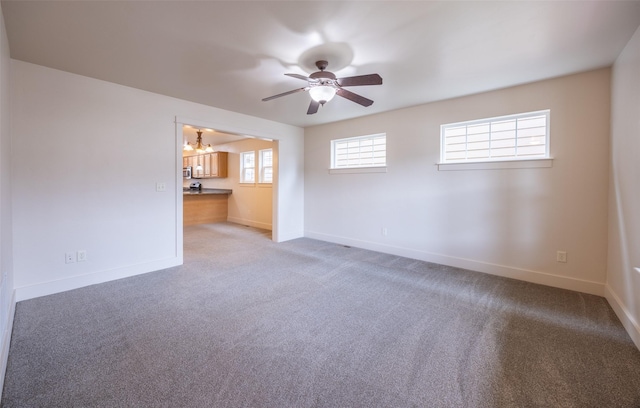 spare room featuring carpet flooring and ceiling fan with notable chandelier