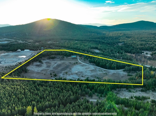 9330 US Highway 2 W, Marion, MT 59925 - aerial view of property and surrounding area featuring a mountain backdrop, a forest, and property boundaries highlighted