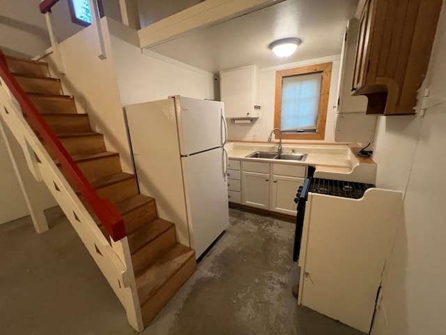 9330 US Highway 2 W, Marion, MT 59925 - kitchen with a sink, freestanding refrigerator, concrete floors, white cabinetry, and stove