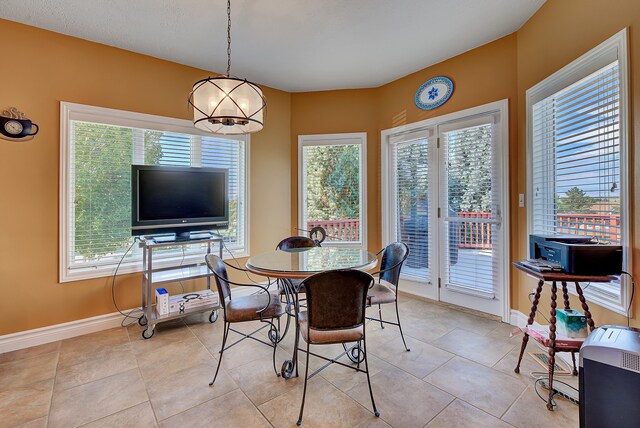 tiled dining room with a notable chandelier