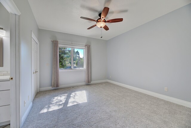 carpeted spare room featuring ceiling fan