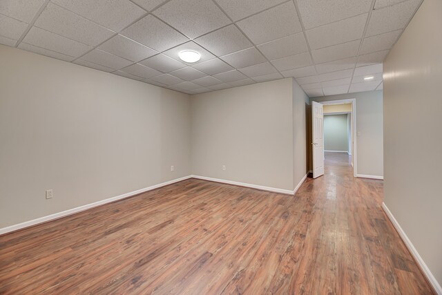 spare room with hardwood / wood-style floors and a paneled ceiling