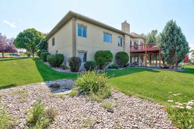 back of house featuring a wooden deck and a lawn