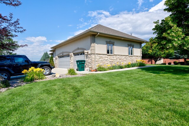 view of side of home with a garage and a lawn