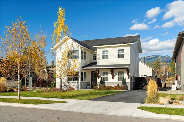 view of front of property with a mountain view and a front lawn