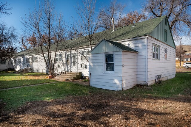 view of side of home with a yard