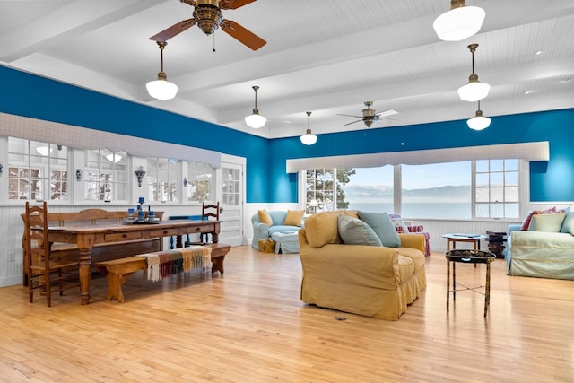 living room featuring beamed ceiling, ceiling fan, and light hardwood / wood-style floors