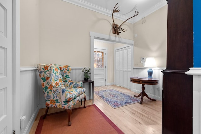 sitting room featuring crown molding and light wood-type flooring