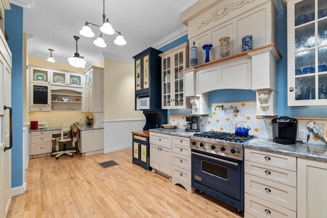 kitchen with premium range, radiator heating unit, decorative light fixtures, ornamental molding, and light stone counters