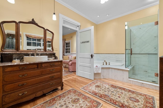 bathroom featuring hardwood / wood-style flooring, crown molding, shower with separate bathtub, and vanity