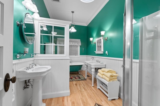 bathroom with hardwood / wood-style flooring, ornamental molding, and shower with separate bathtub