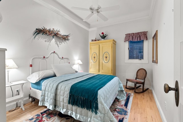 bedroom with ornamental molding, ceiling fan, and light hardwood / wood-style flooring