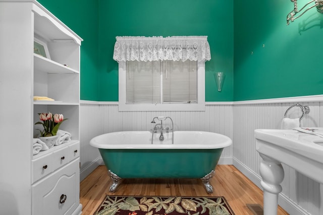 381 Lakeside Blvd, Lakeside, MT 59922 - bathroom featuring a wainscoted wall, wood finished floors, and a freestanding tub
