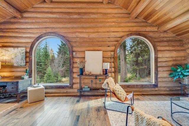 interior space with hardwood / wood-style flooring, lofted ceiling with beams, wooden ceiling, and rustic walls