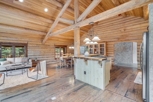 kitchen featuring pendant lighting, stainless steel fridge, dark hardwood / wood-style floors, and a healthy amount of sunlight