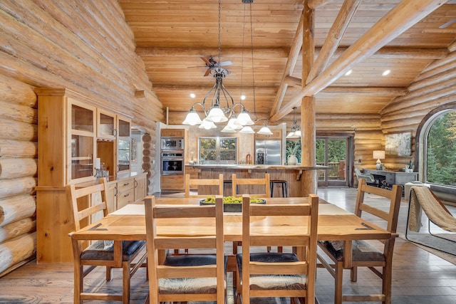 1750 Hill Meadows Rd, Whitefish, MT 59937 - dining space with log walls, wood ceiling with exposed beams, light wood-style flooring, high vaulted ceiling, and a chandelier
