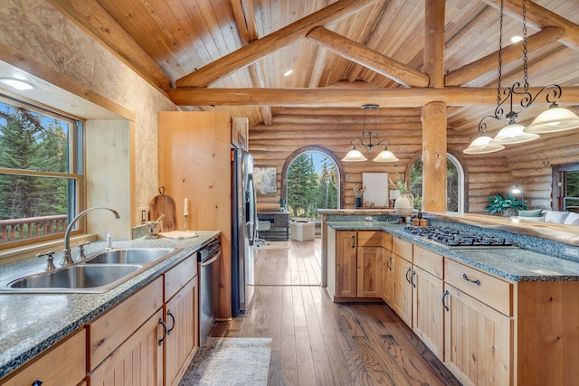 kitchen with sink, appliances with stainless steel finishes, hanging light fixtures, lofted ceiling with beams, and light brown cabinetry