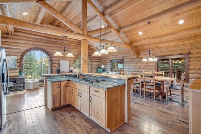 kitchen featuring dark hardwood / wood-style floors, stainless steel gas cooktop, light brown cabinetry, decorative light fixtures, and dark stone counters