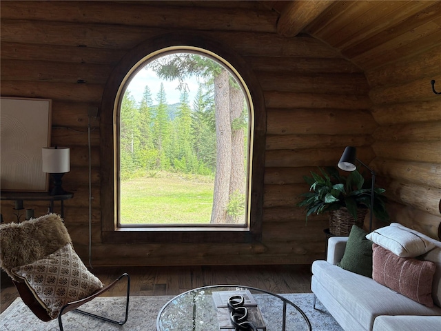1750 Hill Meadows Rd, Whitefish, MT 59937 - living area with rustic walls, hardwood / wood-style floors, wooden ceiling, and a wooded view