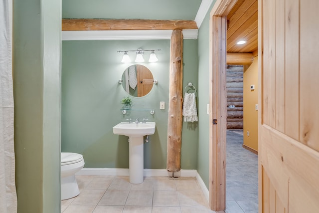 bathroom featuring tile patterned floors, toilet, and rustic walls